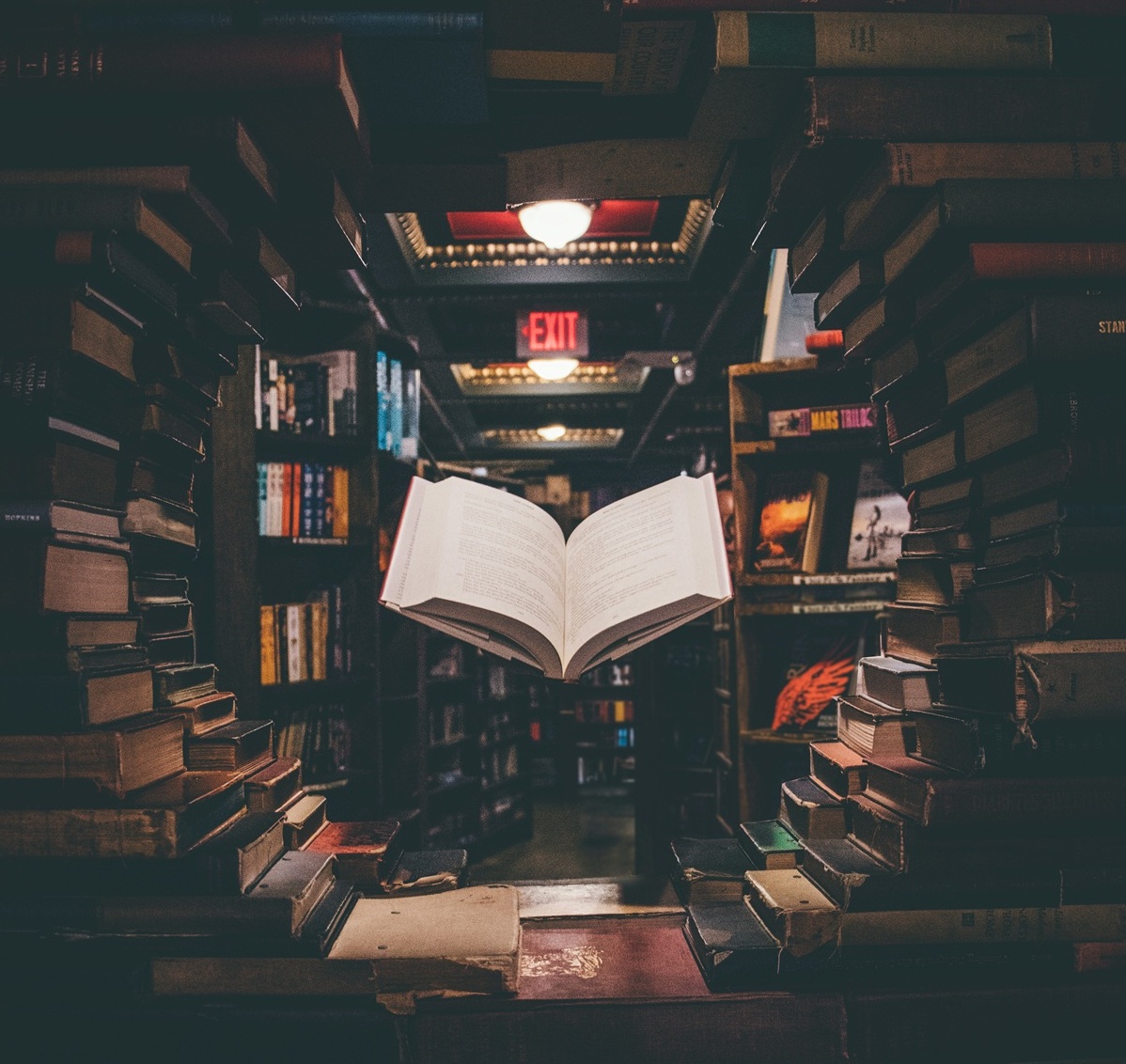 view-of-floating-open-book-from-stacked-books-in-library