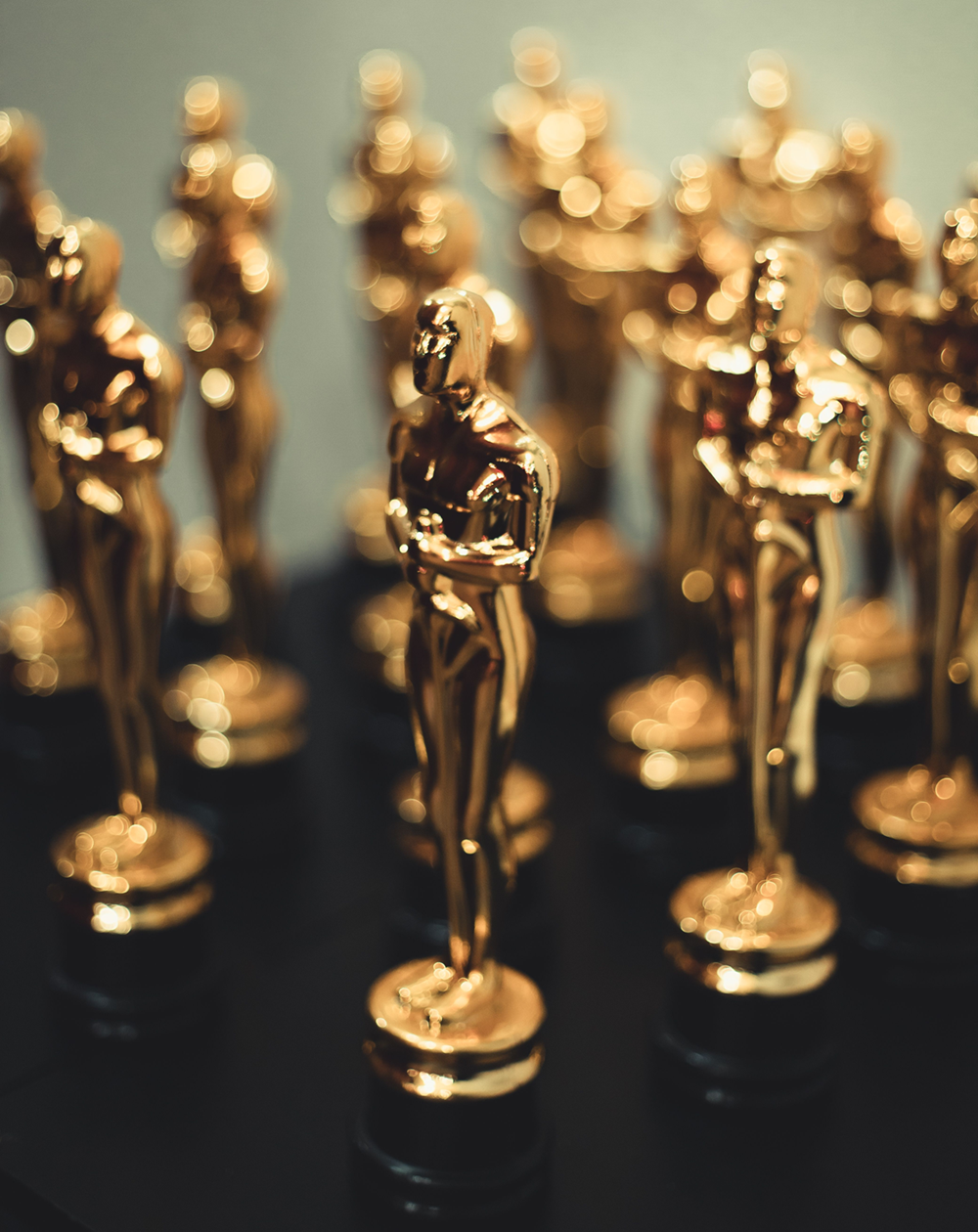Close-up of multiple golden award statuettes on display, capturing elegance and prestige.