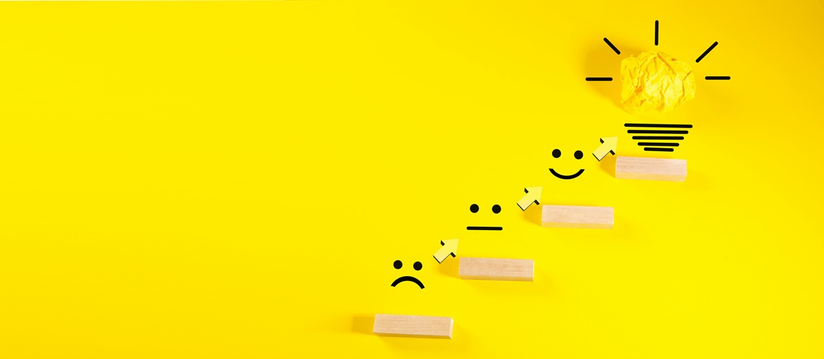 smiley faces ascending toward a light bulb